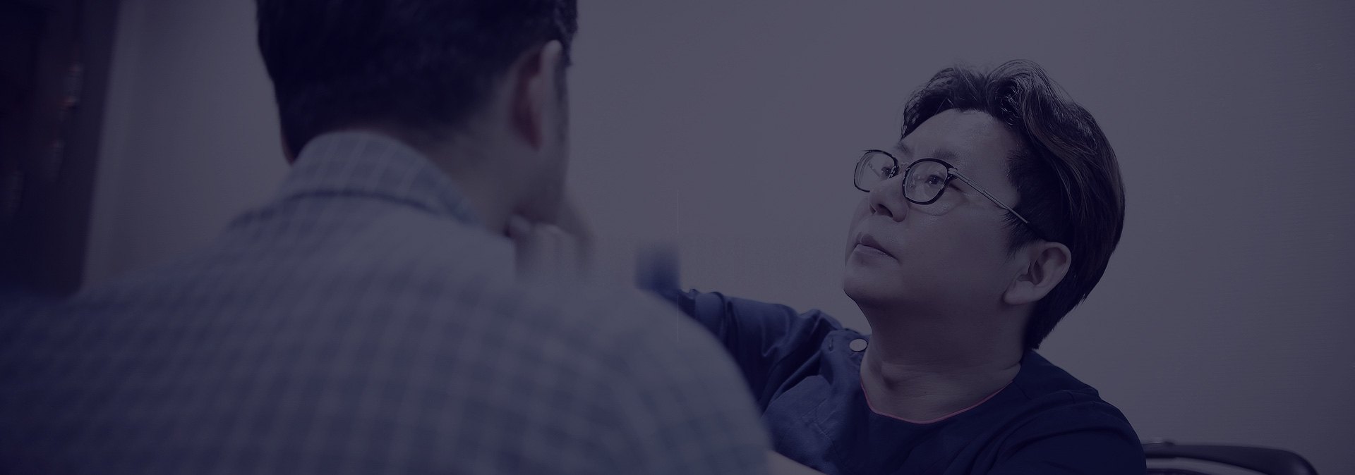 환자의 머리를 직접 살피는 원장